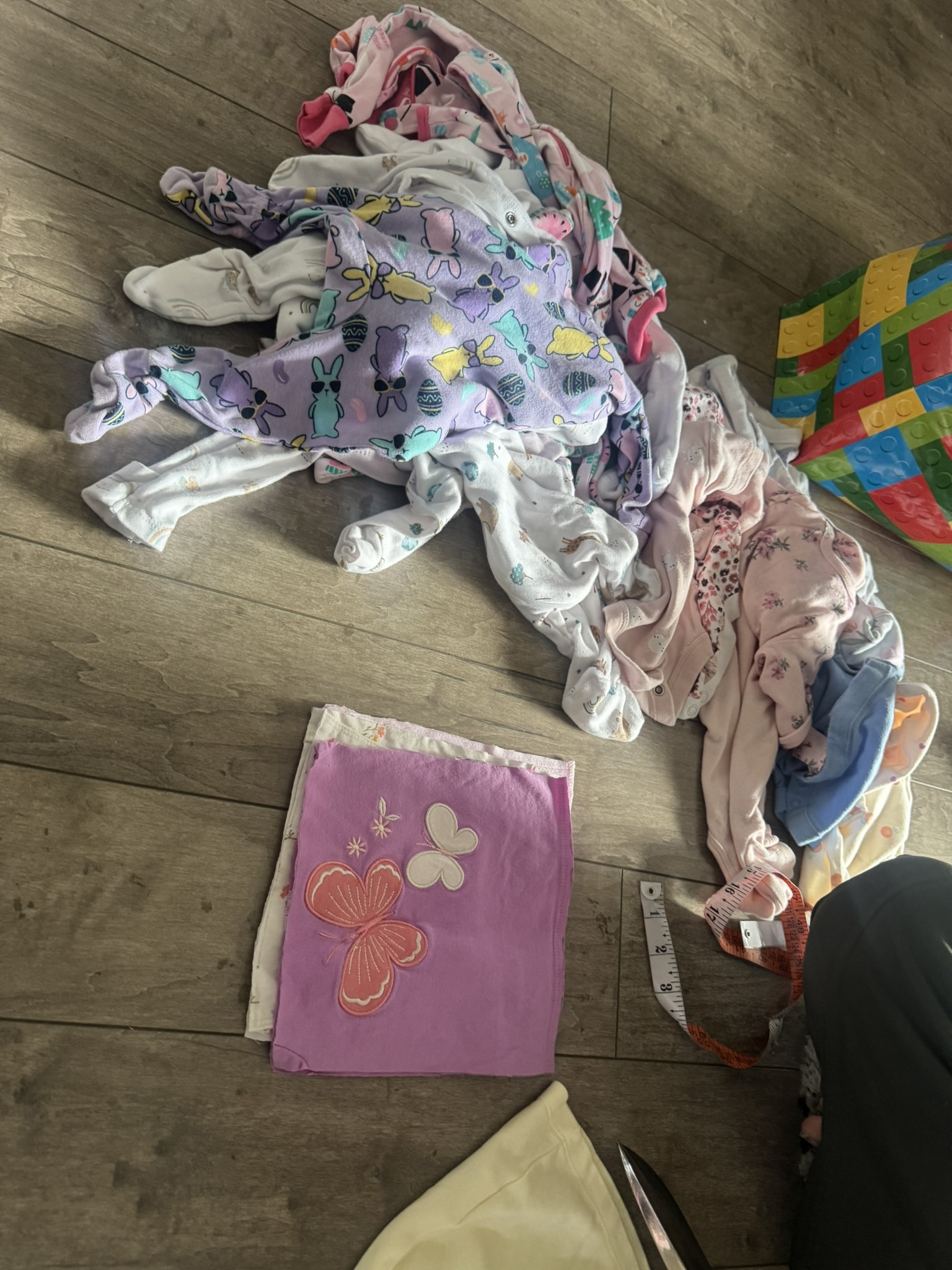 Collection of outgrown baby clothes before becoming a blanket