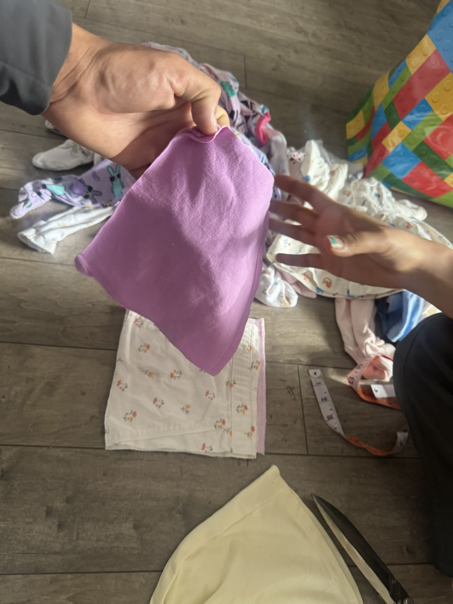 A purple garment being prepared by hand for the blanket