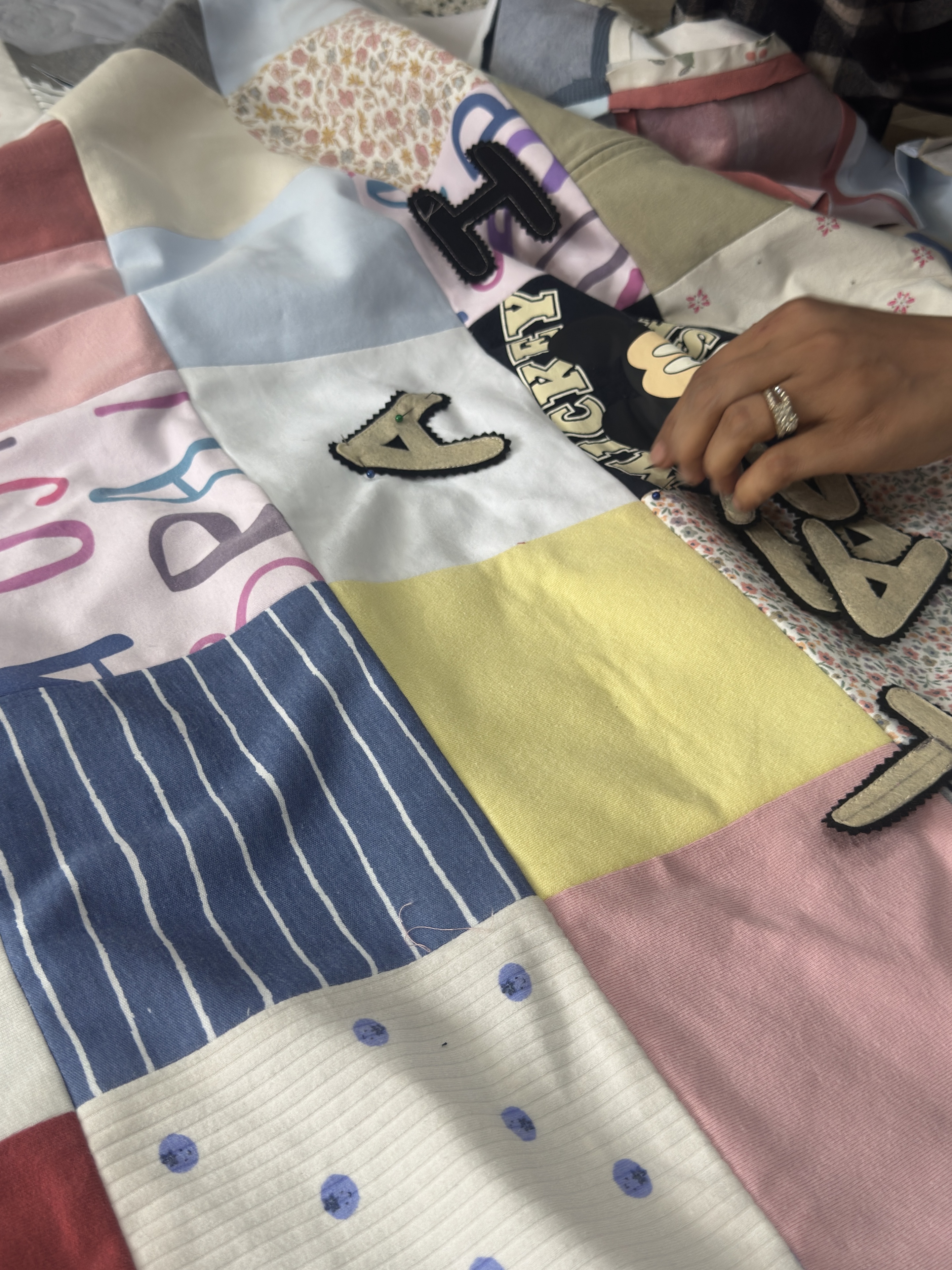 Hands working on the patchwork blanket as it comes together