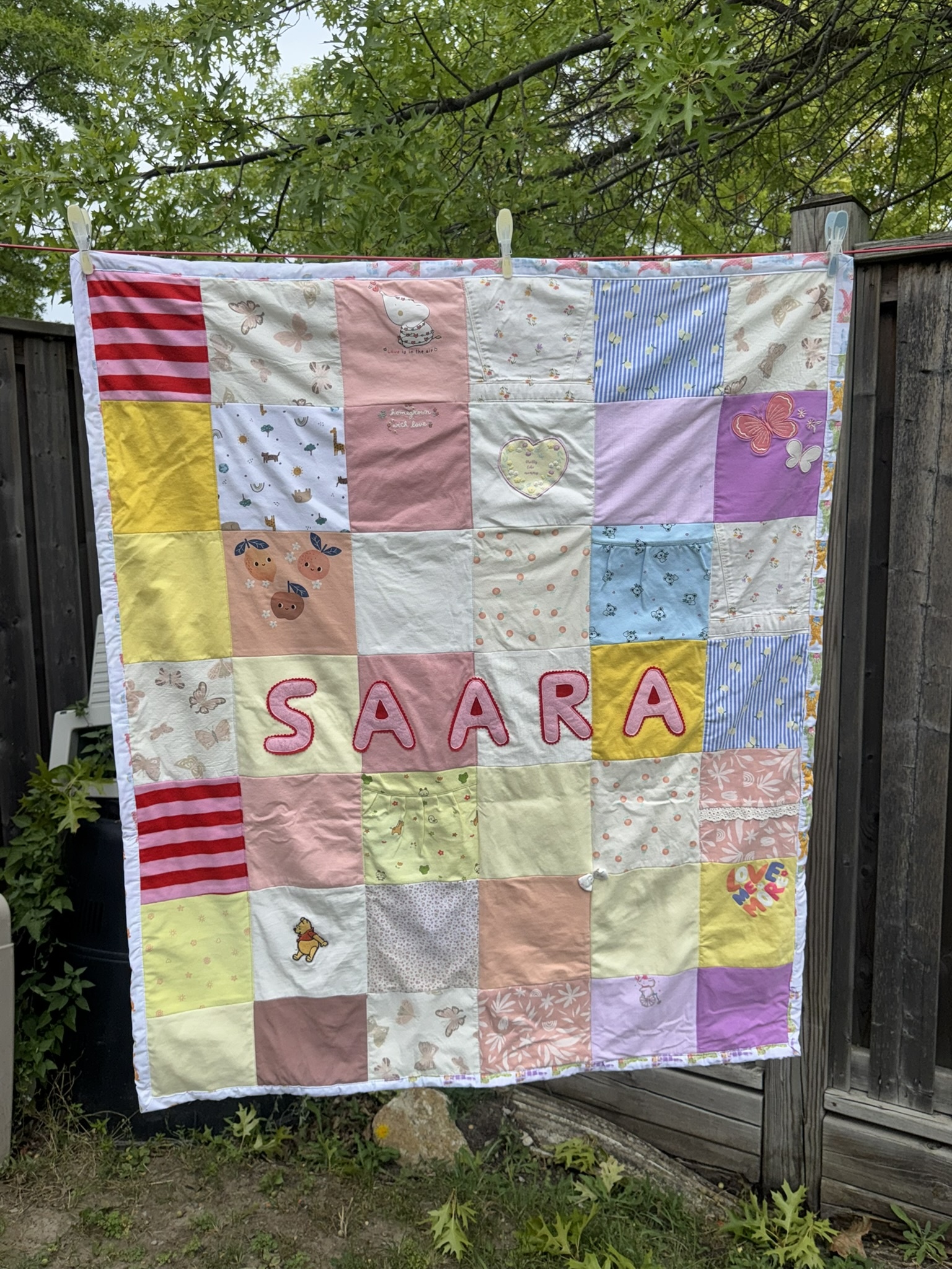 Finished keepsake blanket with colourful squares from baby clothes and the name Saara